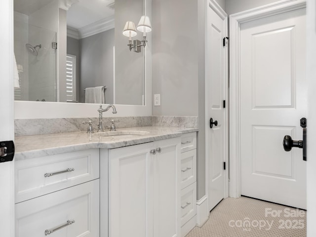 bathroom featuring a shower with door, crown molding, and vanity