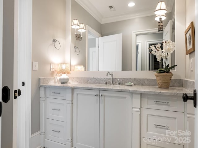 bathroom featuring visible vents, crown molding, and vanity