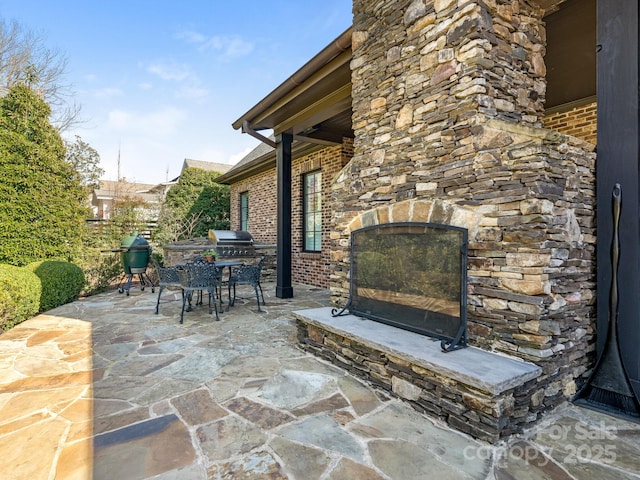 view of patio featuring an outdoor stone fireplace and outdoor dining area