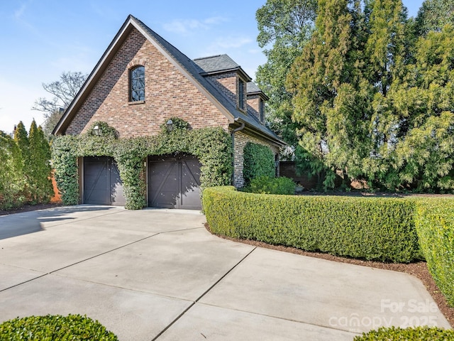 view of front of house with a garage, driveway, and brick siding