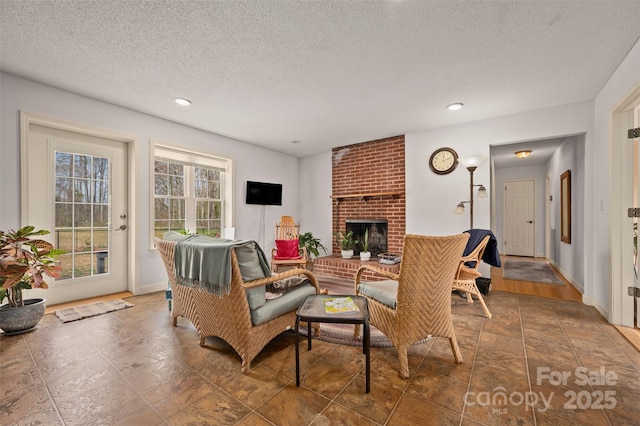 living room featuring a textured ceiling, recessed lighting, and a brick fireplace