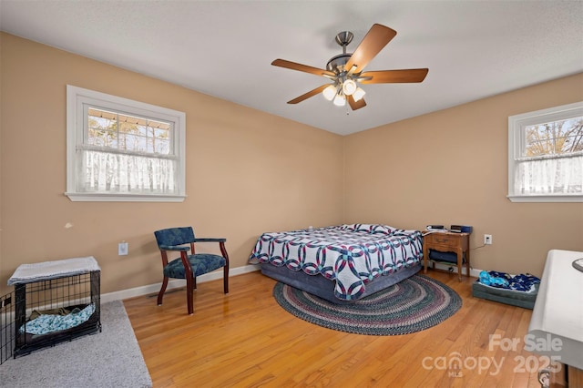 bedroom with baseboards, ceiling fan, and wood finished floors