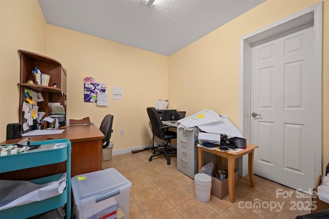 home office featuring light tile patterned floors, baseboards, and a textured ceiling
