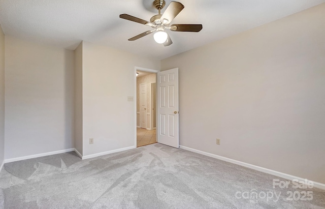 unfurnished room featuring light carpet, ceiling fan, and baseboards