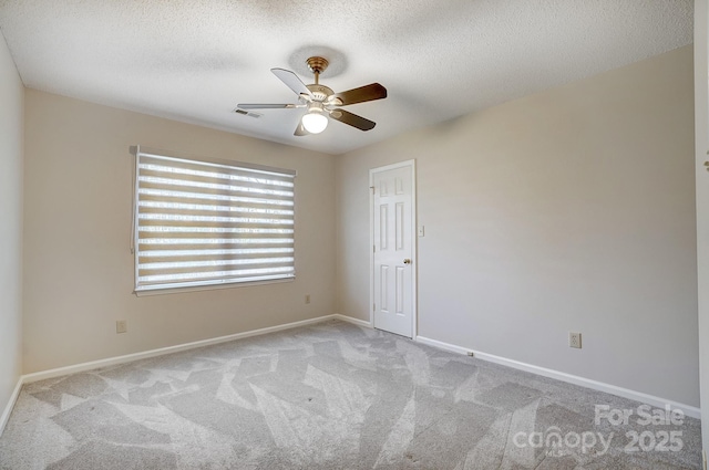 unfurnished room with baseboards, a ceiling fan, visible vents, and light colored carpet