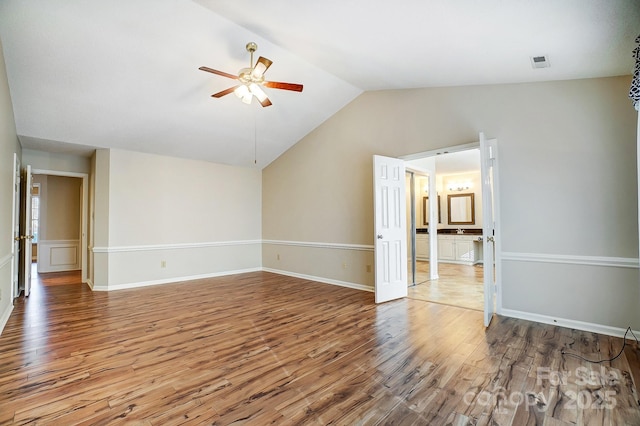 spare room with lofted ceiling, baseboards, a ceiling fan, and wood finished floors