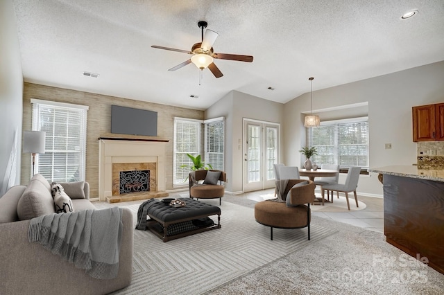 living room with lofted ceiling, visible vents, a textured ceiling, and light tile patterned floors