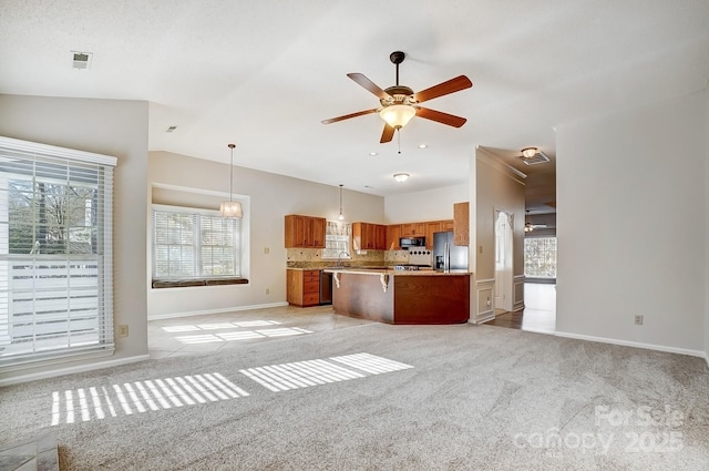 kitchen with a center island, decorative light fixtures, stainless steel appliances, light countertops, and open floor plan