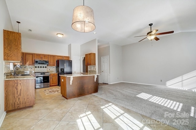 kitchen with a kitchen island, brown cabinets, hanging light fixtures, stainless steel appliances, and a sink