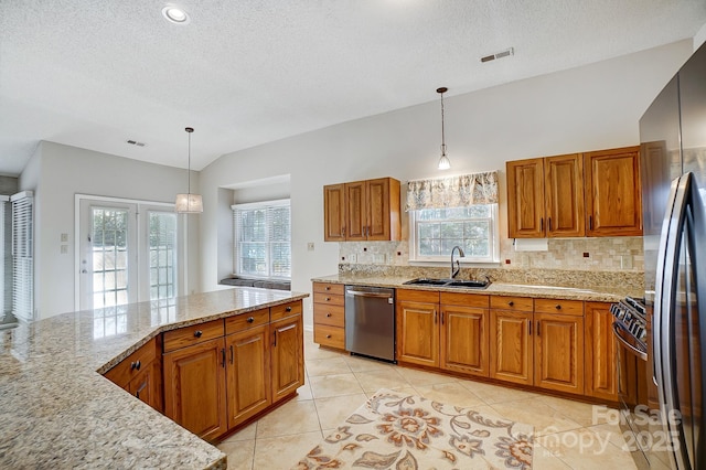 kitchen featuring visible vents, stainless steel dishwasher, pendant lighting, a sink, and gas stove