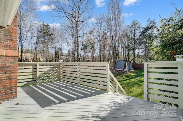 deck with a storage shed, a yard, and an outdoor structure