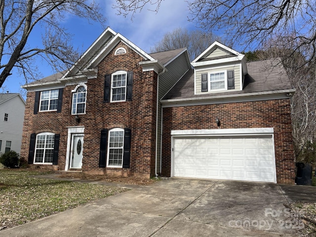 colonial-style house with a garage, concrete driveway, and brick siding