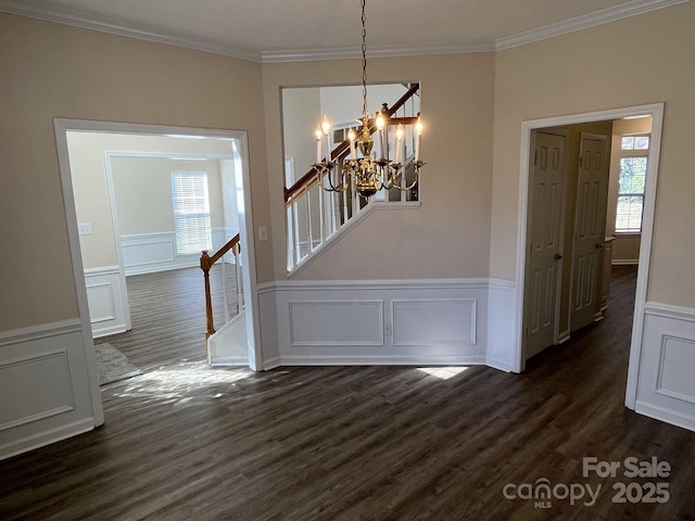 unfurnished dining area featuring stairway, a chandelier, dark wood-type flooring, and ornamental molding