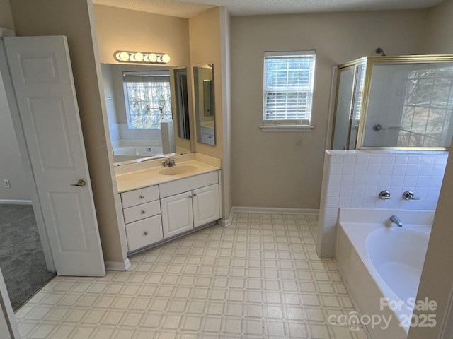 bathroom with a stall shower, baseboards, tile patterned floors, vanity, and a bath