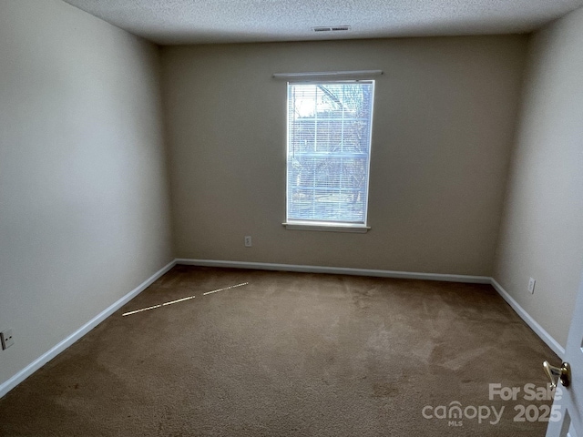 empty room with baseboards, carpet, visible vents, and a textured ceiling