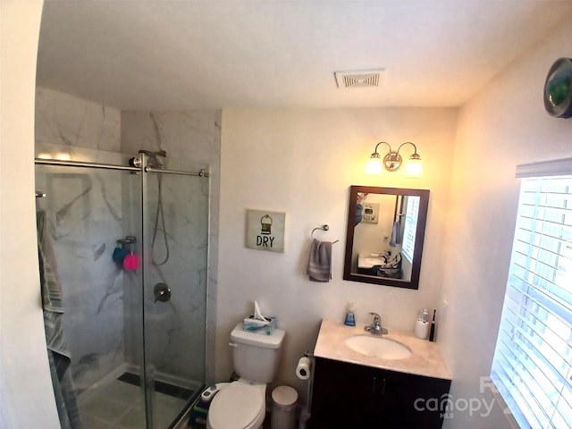 bathroom featuring visible vents, vanity, a marble finish shower, and toilet