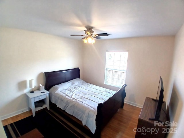 bedroom with a ceiling fan, baseboards, and wood finished floors