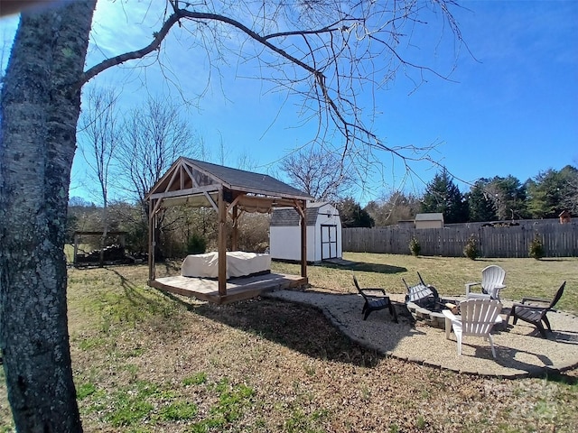 view of yard with a gazebo, an outdoor fire pit, a shed, a fenced backyard, and an outdoor structure