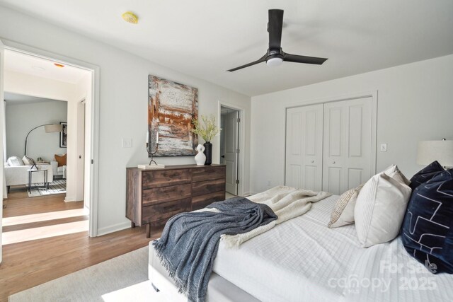 bedroom featuring ceiling fan, a closet, wood finished floors, and baseboards