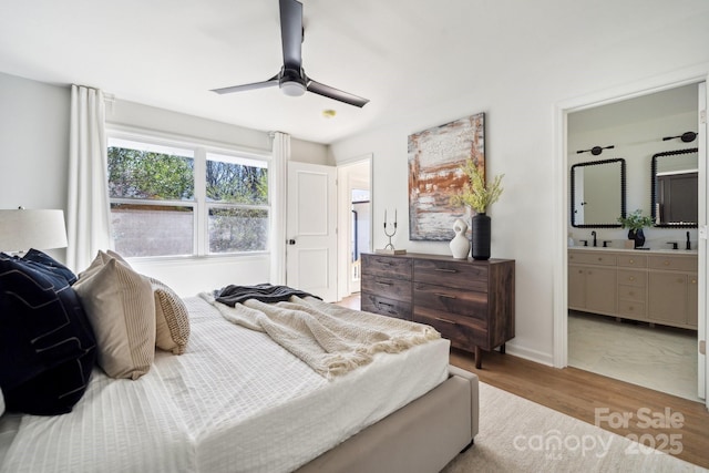 bedroom with a ceiling fan, baseboards, ensuite bath, and wood finished floors