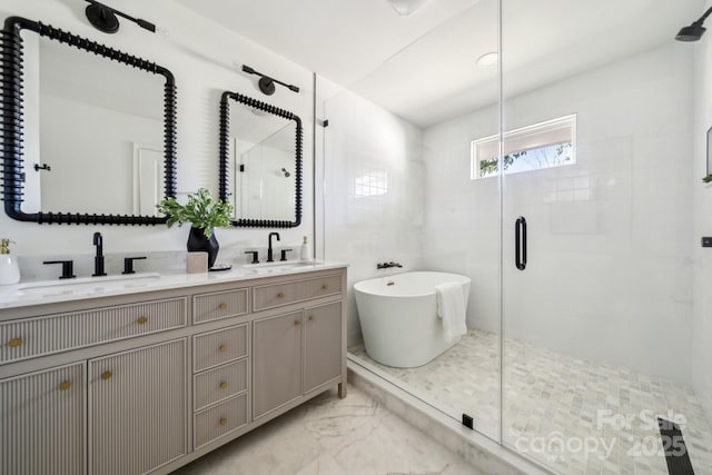 bathroom featuring marble finish floor, a sink, a shower stall, and double vanity