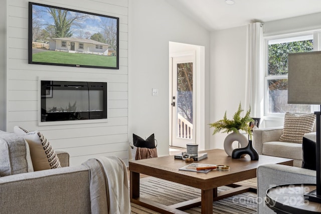 living room with lofted ceiling and a fireplace