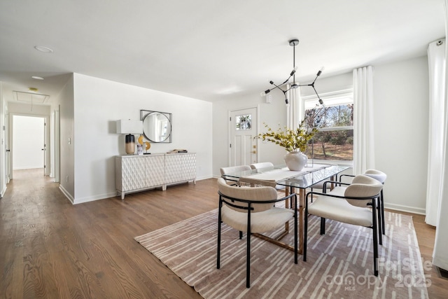 dining area featuring attic access, baseboards, and wood finished floors