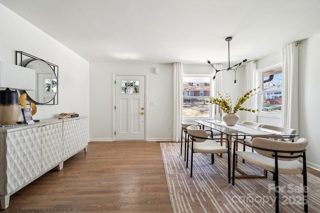 dining space featuring dark wood-style floors and baseboards