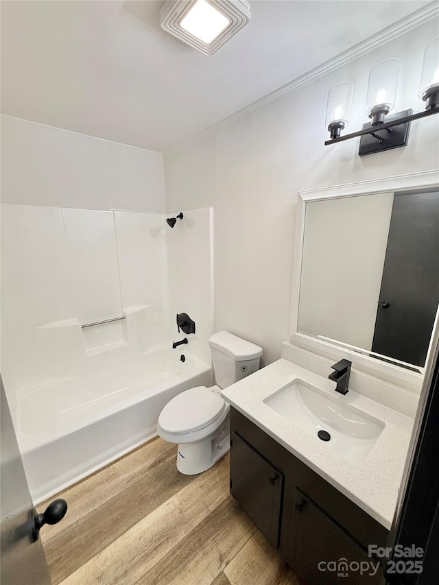 bathroom with toilet, shower / bath combination, wood finished floors, and vanity