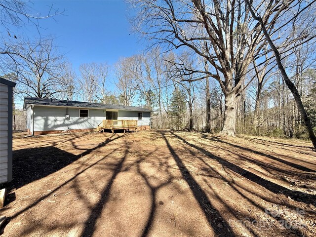 view of yard with a deck and driveway