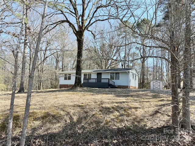 view of front of property featuring an outbuilding, a storage shed, crawl space, and a wooden deck