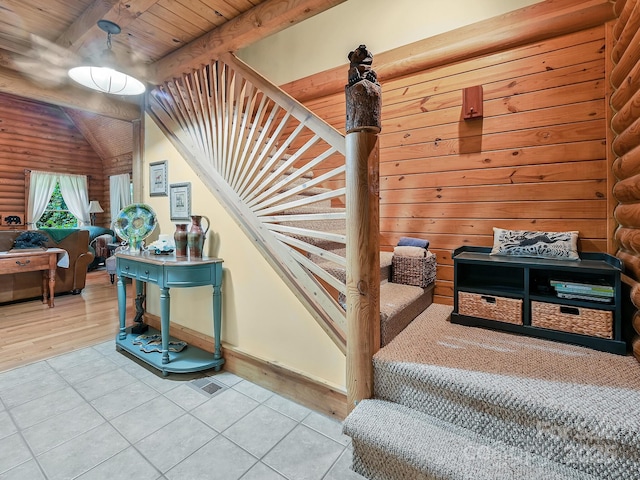 staircase featuring wood ceiling, beamed ceiling, log walls, and tile patterned floors