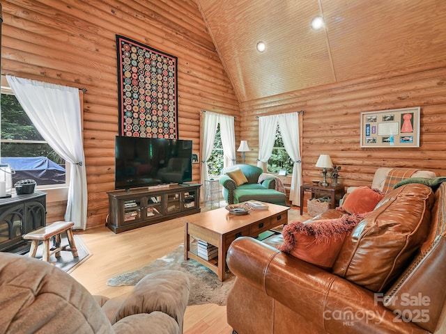 living area with high vaulted ceiling, wood finished floors, a wood stove, and recessed lighting