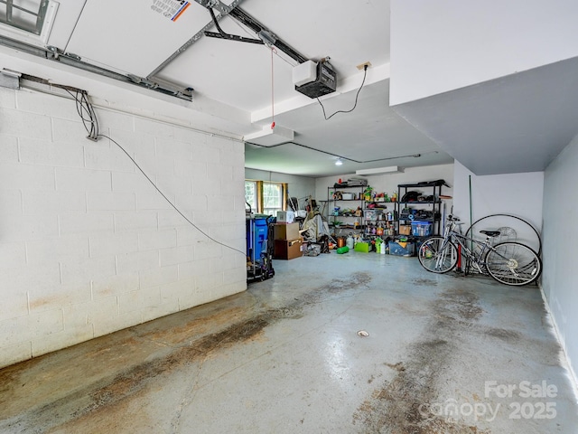 garage with a garage door opener and concrete block wall