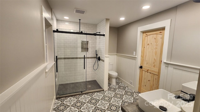 621 Watts St NE, Valdese, NC 28690 - bathroom featuring toilet, visible vents, a shower stall, and a wainscoted wall