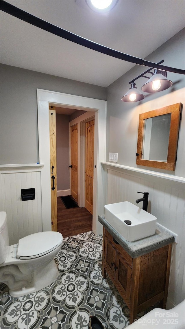 621 Watts St NE, Valdese, NC 28690 - half bath featuring vanity, toilet, and a wainscoted wall