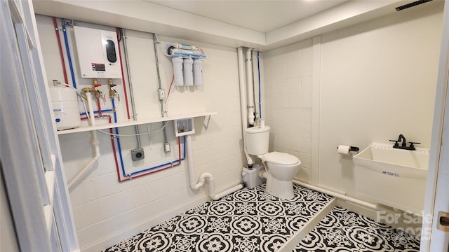 621 Watts St NE, Valdese, NC 28690 - bathroom featuring visible vents, concrete block wall, water heater, and toilet