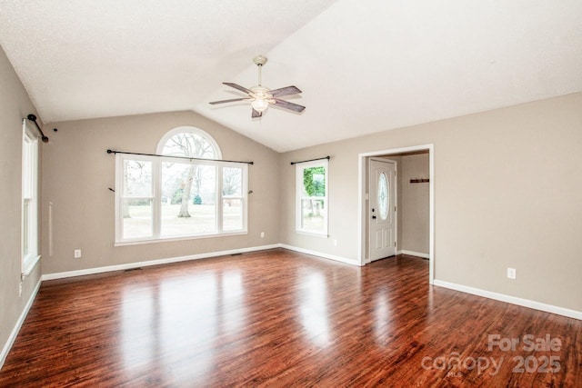 empty room with a barn door, baseboards, lofted ceiling, ceiling fan, and wood finished floors