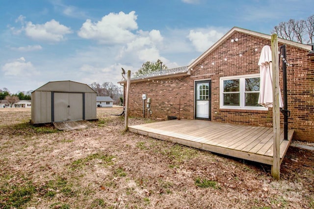 exterior space featuring brick siding, an outdoor structure, a deck, and a shed