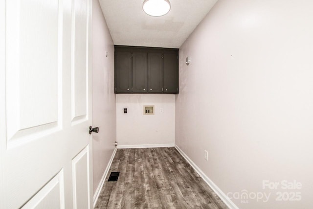 laundry area featuring cabinet space, visible vents, baseboards, dark wood finished floors, and hookup for a washing machine