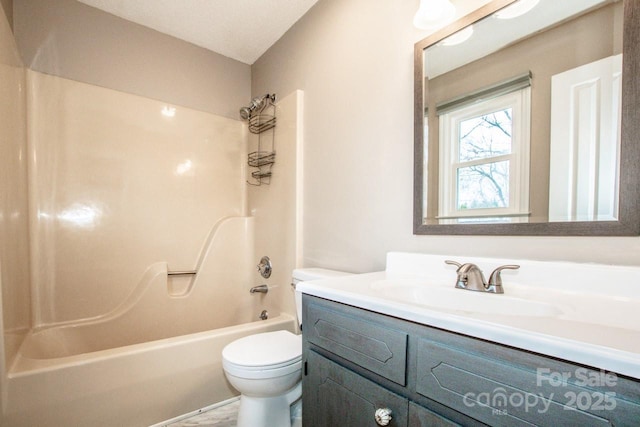 bathroom with bathtub / shower combination, vanity, and toilet