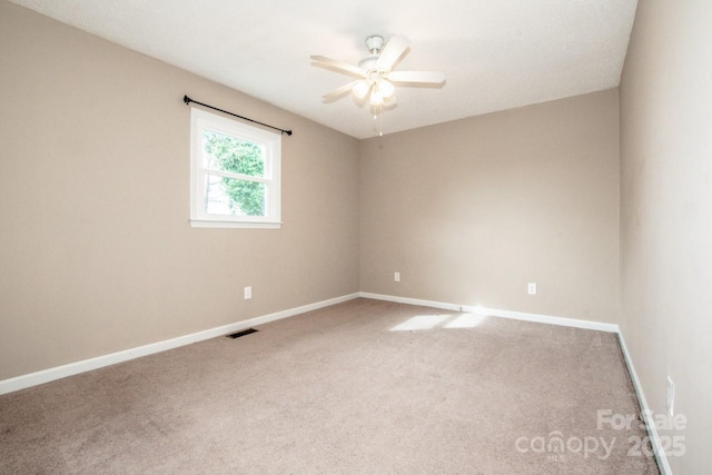 unfurnished room featuring carpet floors, baseboards, visible vents, and a ceiling fan