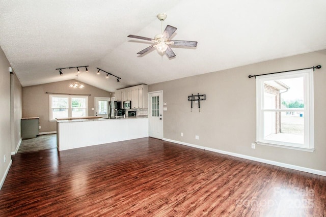 unfurnished living room featuring ceiling fan, baseboards, vaulted ceiling, and dark wood-style flooring