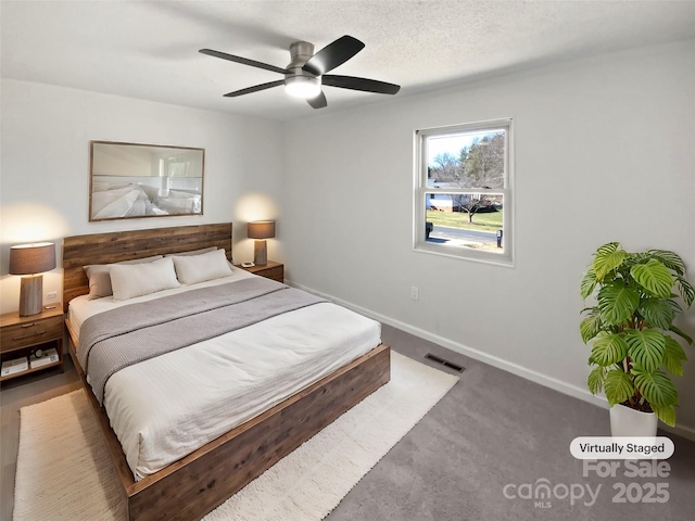 carpeted bedroom featuring visible vents, ceiling fan, a textured ceiling, and baseboards