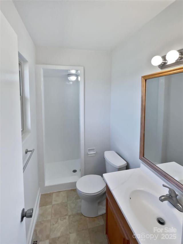 full bathroom with a shower stall, vanity, and toilet