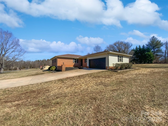 exterior space with concrete driveway, an attached garage, and a front yard