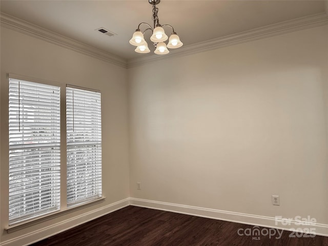 spare room with baseboards, visible vents, dark wood finished floors, ornamental molding, and a chandelier