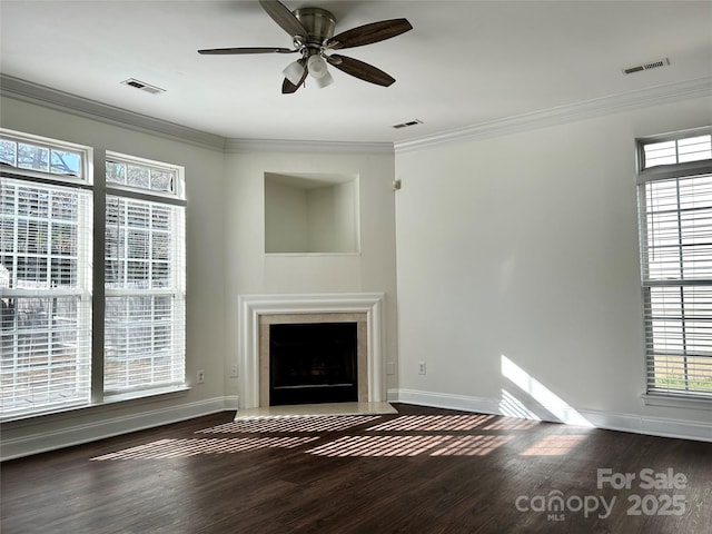 unfurnished living room with wood finished floors, a fireplace with flush hearth, visible vents, and crown molding