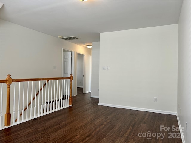 empty room featuring visible vents, baseboards, and wood finished floors