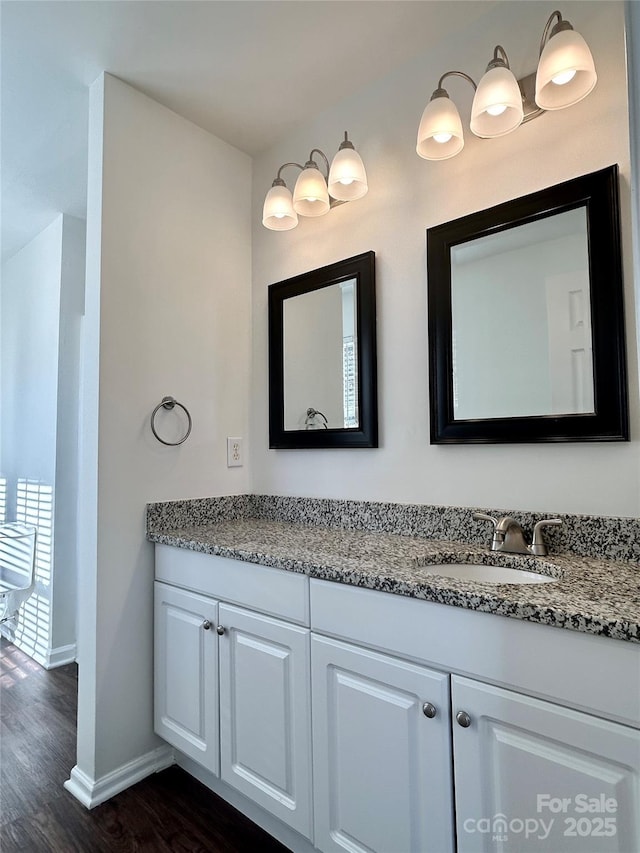 bathroom featuring wood finished floors, vanity, and baseboards